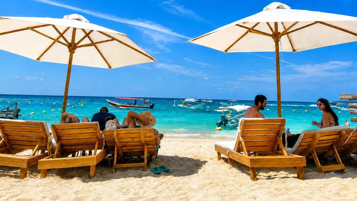 Beach loungers under palm shade at a Rosario Islands beach club on a full-day tour from Cartagena, Colombia