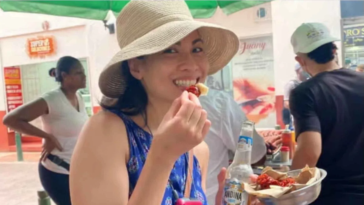 A guide sharing Colombian street snacks with travelers on a Cartagena food tasting tour in the Walled City, Colombia