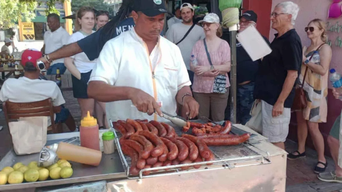 Travelers sampling fried snacks from a street cart on a Cartagena food and culture walking tour, Colombia