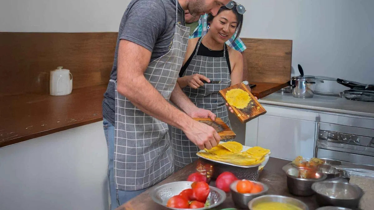 Chefs guiding travelers through a Colombian cooking class in a Cartagena historic center kitchen, Colombia