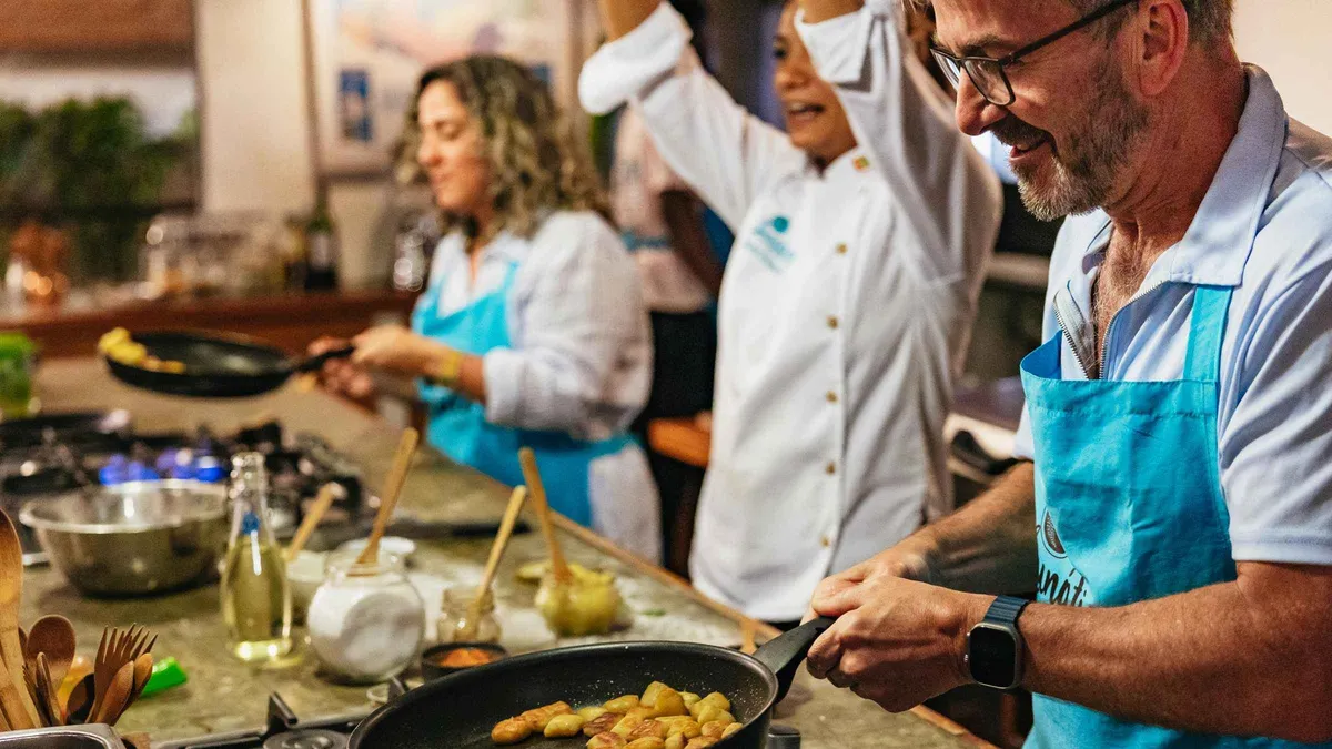 A local chef teaching a small group to plate Caribbean coastal cuisine in a Cartagena cooking class, Colombia