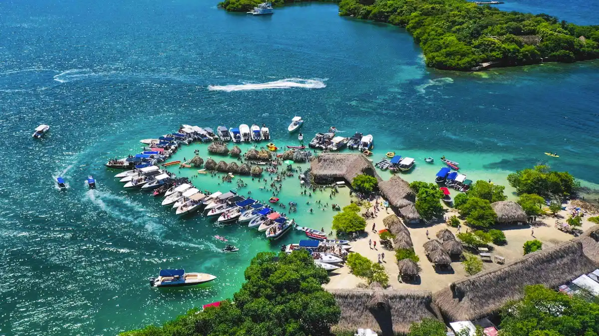 A speedboat approaching a white-sand beach club on a 5-stop Rosario Islands day trip from Cartagena, Colombia