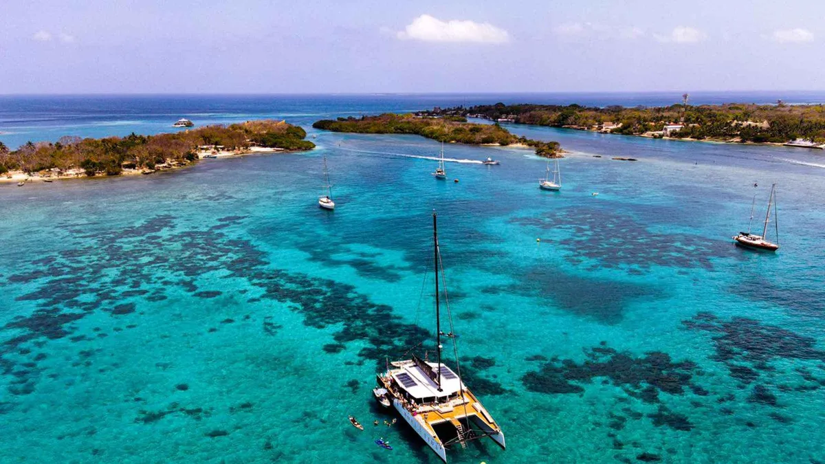 A sailing catamaran anchored off a coral-fringed beach on a Rosario Islands day trip from Cartagena, Colombia